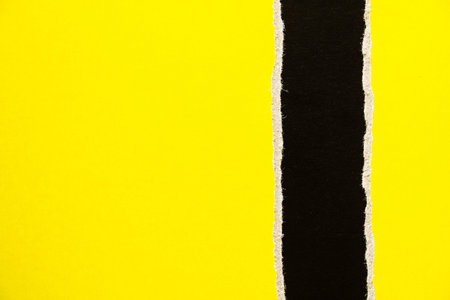 Black and yellow torn and ripped cardboard paper texture background. Can be used for text.
