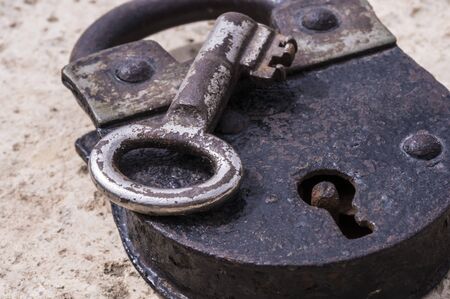 Old rusty metal padlock and keyの写真素材