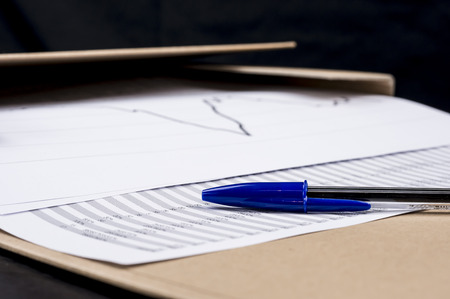 Close up of a pen on statistical charts and numbersの写真素材