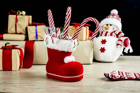 Christmas boot fill with candy canes, with snowman and presents in the backgroundの写真素材