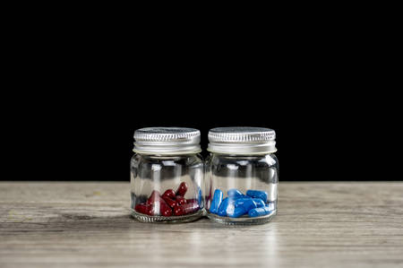 Red and blue prescription pills in bottlesの写真素材