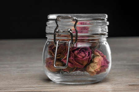Close up shot of a vintage jar filled with pink dried rosesの写真素材