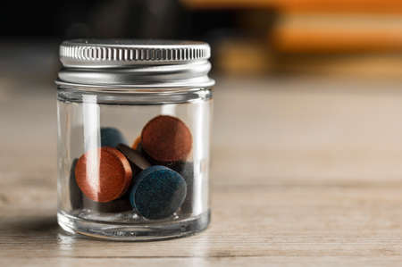 Close up shot of colorful pills in glass and metal containerの写真素材