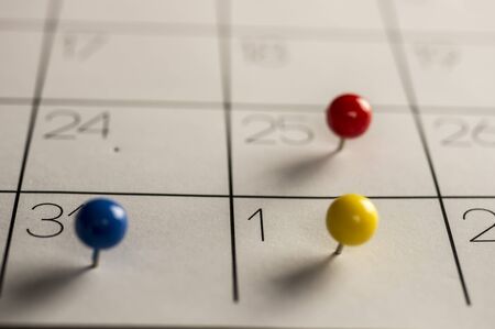 Close up shot of Christmas day New years eve and day, marked with different color pins on calendarの写真素材