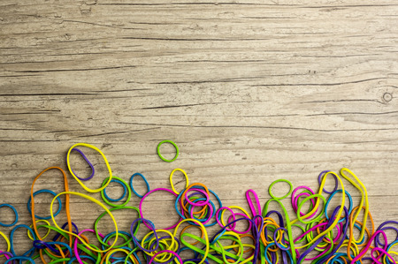 Close up shot of vibrant colored rubber bands on wood backgroundの写真素材