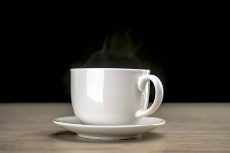 Close up shot of a steaming coffee in white cupの写真素材