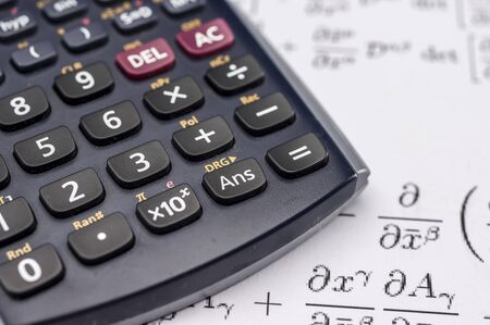 Close up shot of scientific calculator and mathematical equations sheetsの写真素材