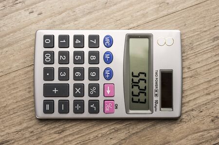 Close up shot of a calculator on wooden tableの写真素材