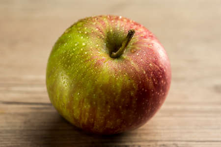 Close up shot of a red apple on wooden tableの写真素材