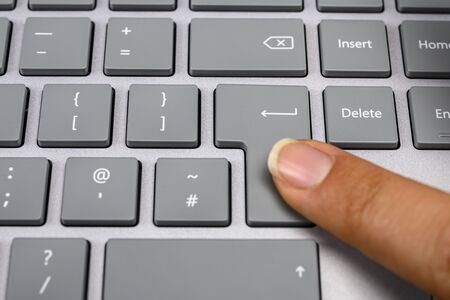 Finger pressing the enter key close upの写真素材
