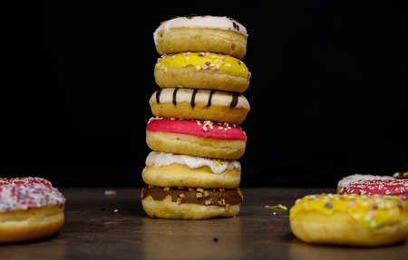 Donuts of multiple colors piled up close upの写真素材