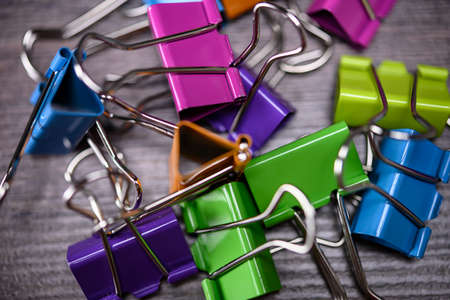 Bunch of multicolored binder clips on tableの写真素材