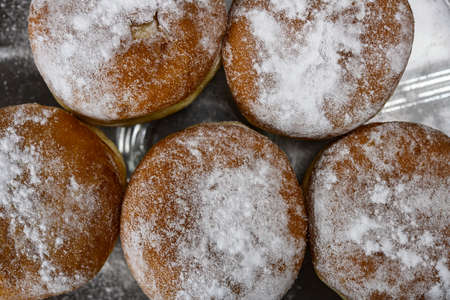Chocolate or jelly filled donuts sprinkled with powder sugarの写真素材