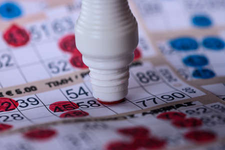 Playing Bingo. Marking numbers with red markerの写真素材
