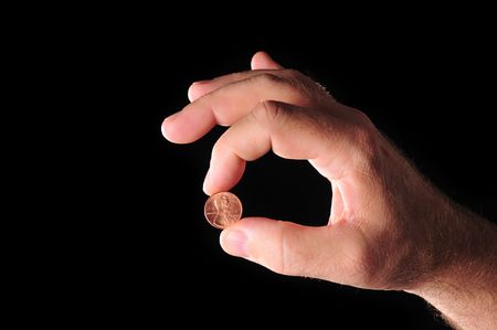 a coin in hand in todays troubled economic timesの写真素材
