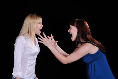 a screaming mad woman reaching out to grab another womanの写真素材