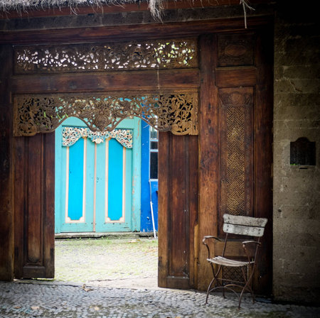 chair in front of an entrance to a balinese styled houseの写真素材