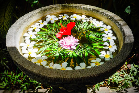 flower offering in a water bowl. arrangement of different flowers.の写真素材