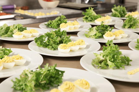many dishes in the kitchen with salad and decorated eggs, ready for guestsの写真素材