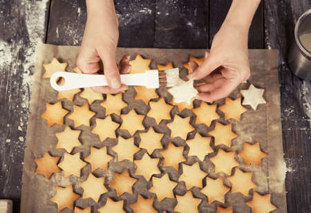 white chocolate is spread on cookies in star shapeの写真素材