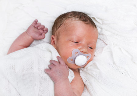 lying baby a week after the baby with pacifier