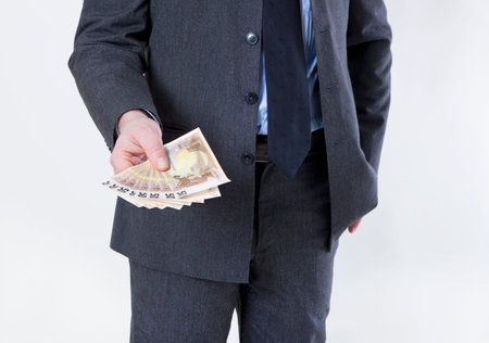 a businessman holding out a lot of euro bills in hand