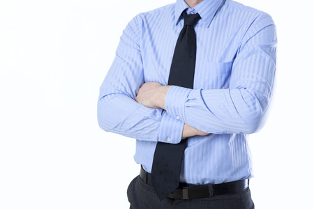 a businessman in shirt and tie holds his arms crossed, no faceの写真素材