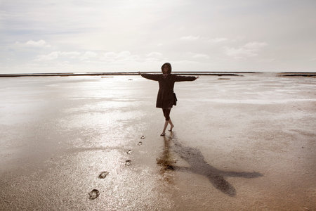 a holidaymaker walks in the Wadden Sea on the North Coast
