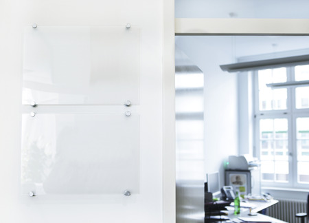 A white office corridor with signs on the wallの写真素材