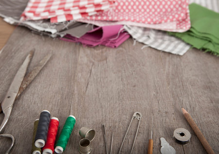 colorful fabrics and accessories to tailor lie on a wooden underground