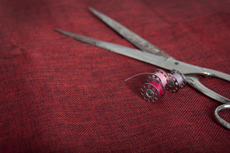 to sew a red cloth with scissors and threadの写真素材