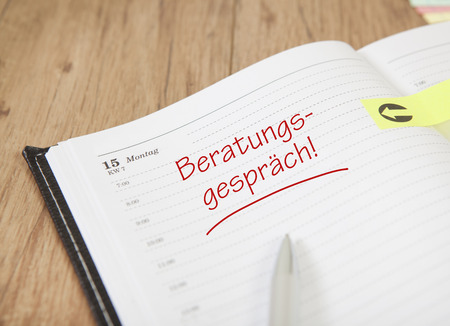 an open calendar with Post it and the text consultationの写真素材