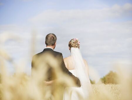 a bride and her groom entwined tightly in natureの写真素材