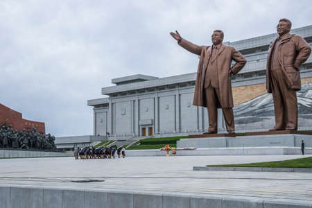North Korean people bowing in front of Kim Il Sung and Kim Jong Il statues in Mansudae Grand Monument, Pyongyang, North Koreaのeditorial素材