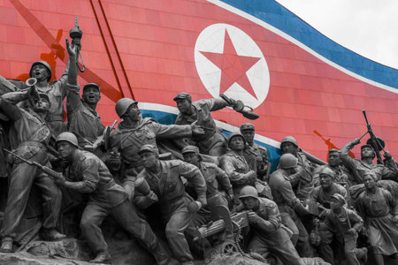 A North Korean flag and several bronze statues are part of the Socialist Revolution Monument, Pyongyang, North Koreaのeditorial素材