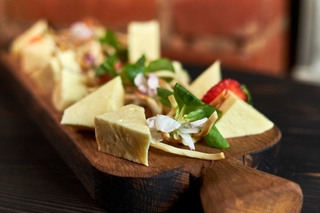 Pieces of cheese on a board with vegetables hdの写真素材