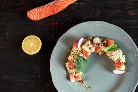 Salad with salmon and radish in the form of a month on a plate jpgの写真素材