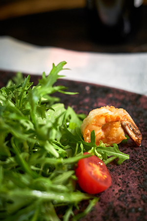 Salad with shrimps and arugula serve on a table with wineの写真素材