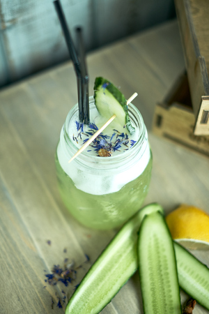 Homemade cucumber and mint lemonade in a glass on a blue wooden background. jpgの写真素材