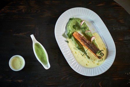 Baked trout with sauce and broccoliの写真素材