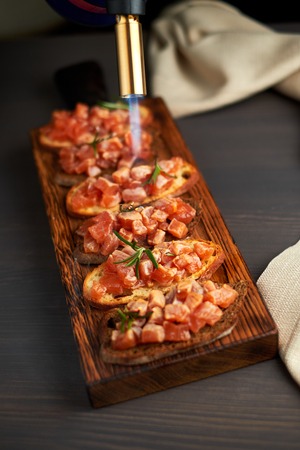 bruschetta with delicious fish on a cream cushion with capers and olive oilの写真素材