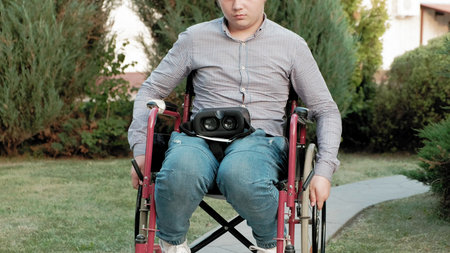 A disabled man in a wheelchair chair uses a virtual reality helmet