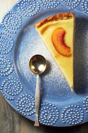 Cottage cheese casserole with sour cream on white plate. Cottage cheese baked pudding peachの写真素材