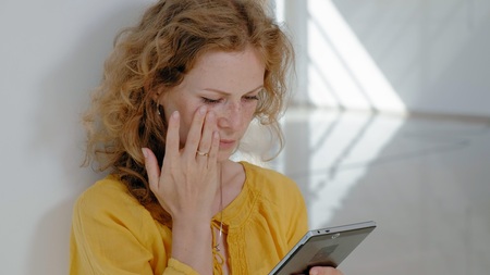 Young beautiful business woman, by the window with a tabletの写真素材