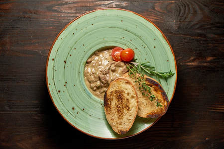 Beef stroganoff with croutons. Dark wooden background. Restaurant menuの写真素材