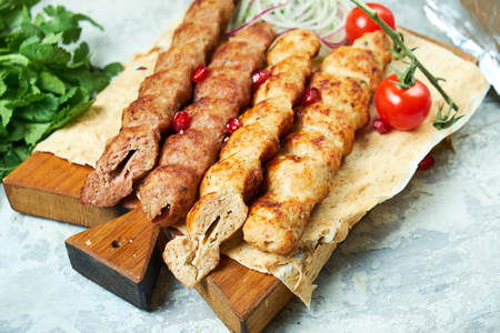 Plates of meat with barbecue and kebab, on gray backgroundの写真素材