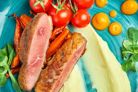 Fried meat with shredded potatoes and tomatoesの写真素材