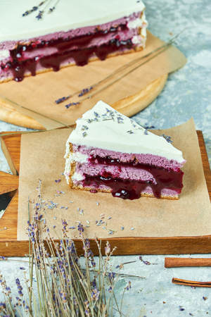Lavender cake on a wooden board with parchment paperの写真素材