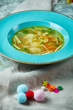 Chicken soup On a gray textured background. Beautiful serving of dishesの写真素材