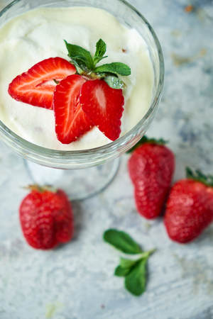Ice cream with strawberries in a glass vase. Gray textured background. Dessertの写真素材